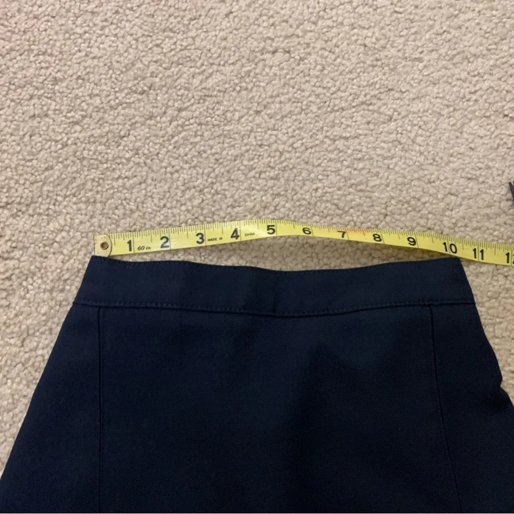 Navy blue pleated skirt with adjustable waist.
